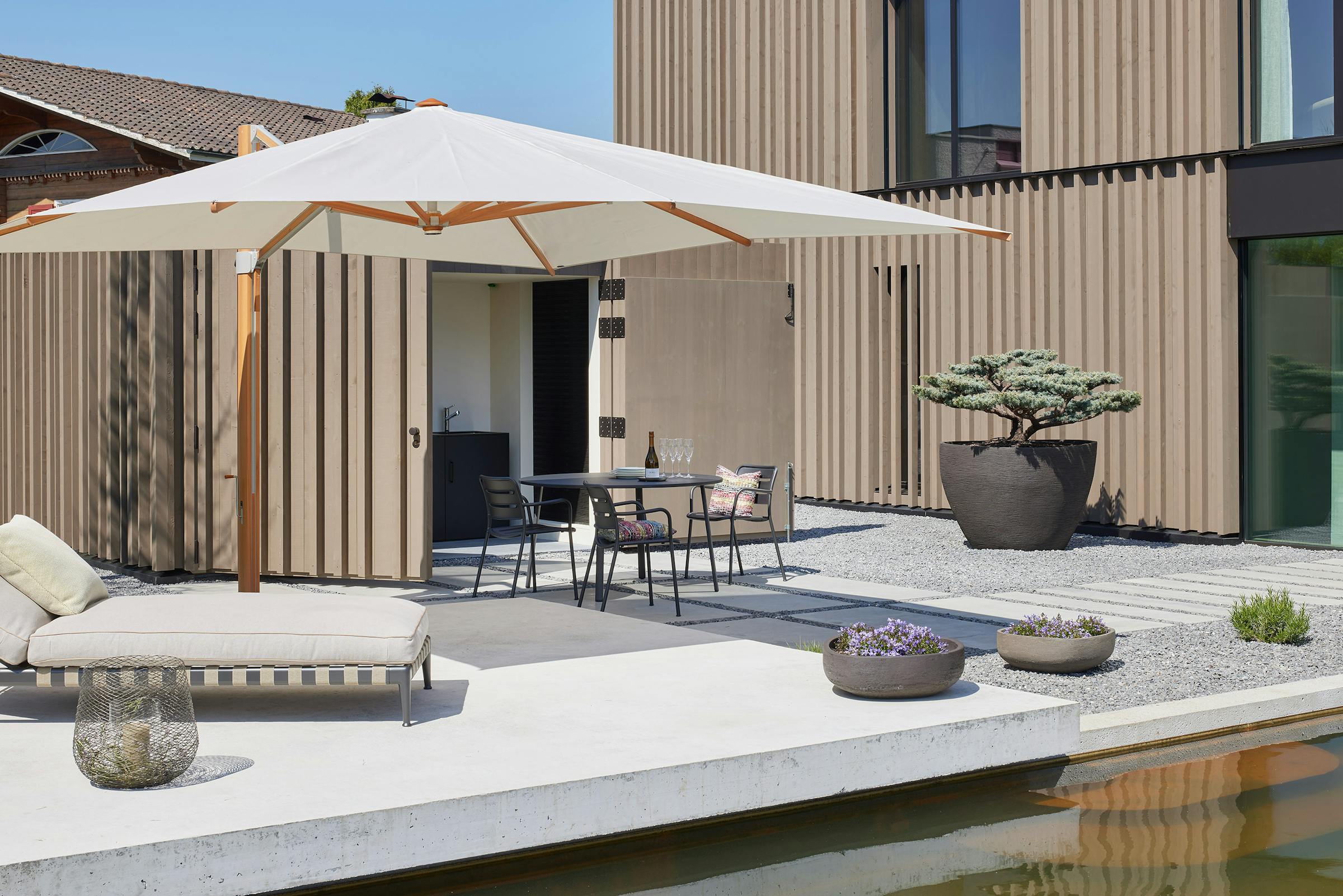 Courtyard with a daybed and an outdoor table in the sun