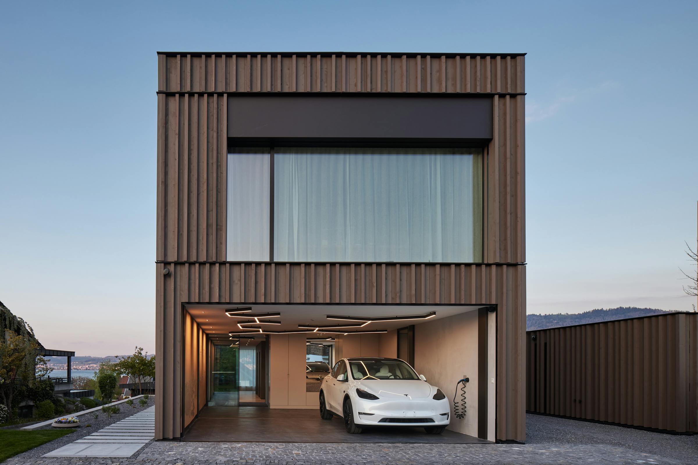 Modernist building with a white Tesla in the garage