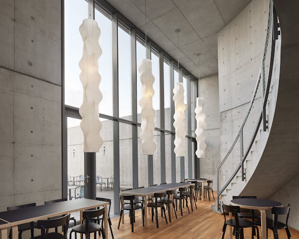 View from the Tadao Ando Pavilion at the vitra campus in Weil am Rhein into the inner courtyard, long paper lights by Ismau Noguchi hang from the ceiling