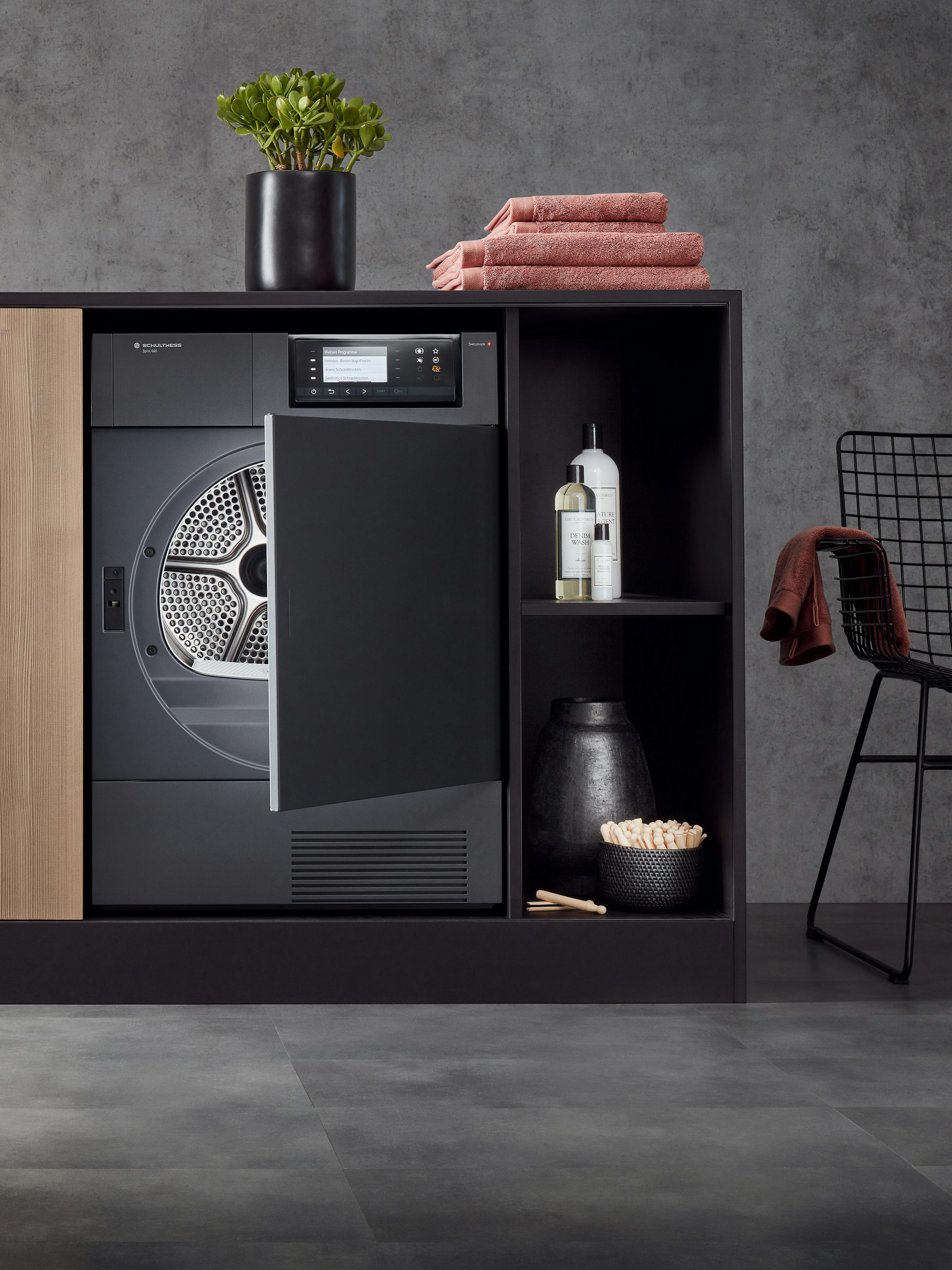 Tumble dryer in a built-in cupboard with laundry accessories