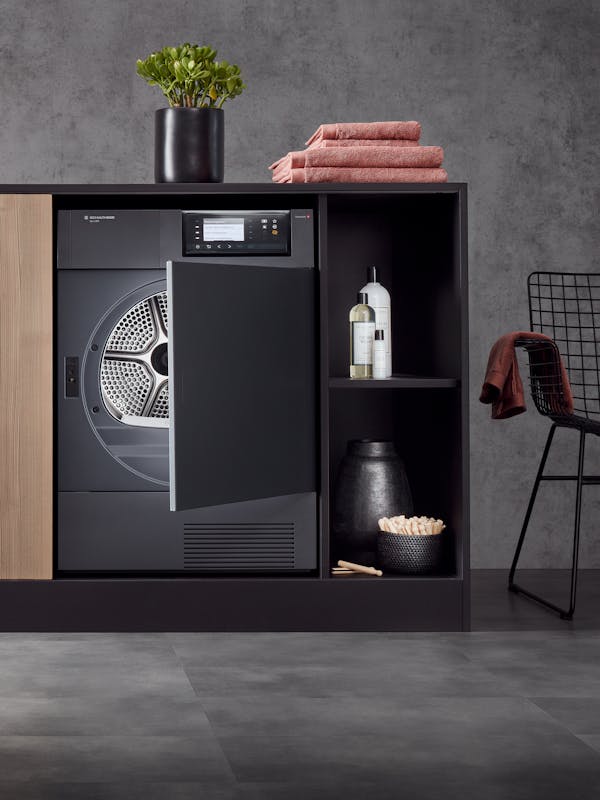 Tumble dryer in a built-in cupboard with laundry accessories