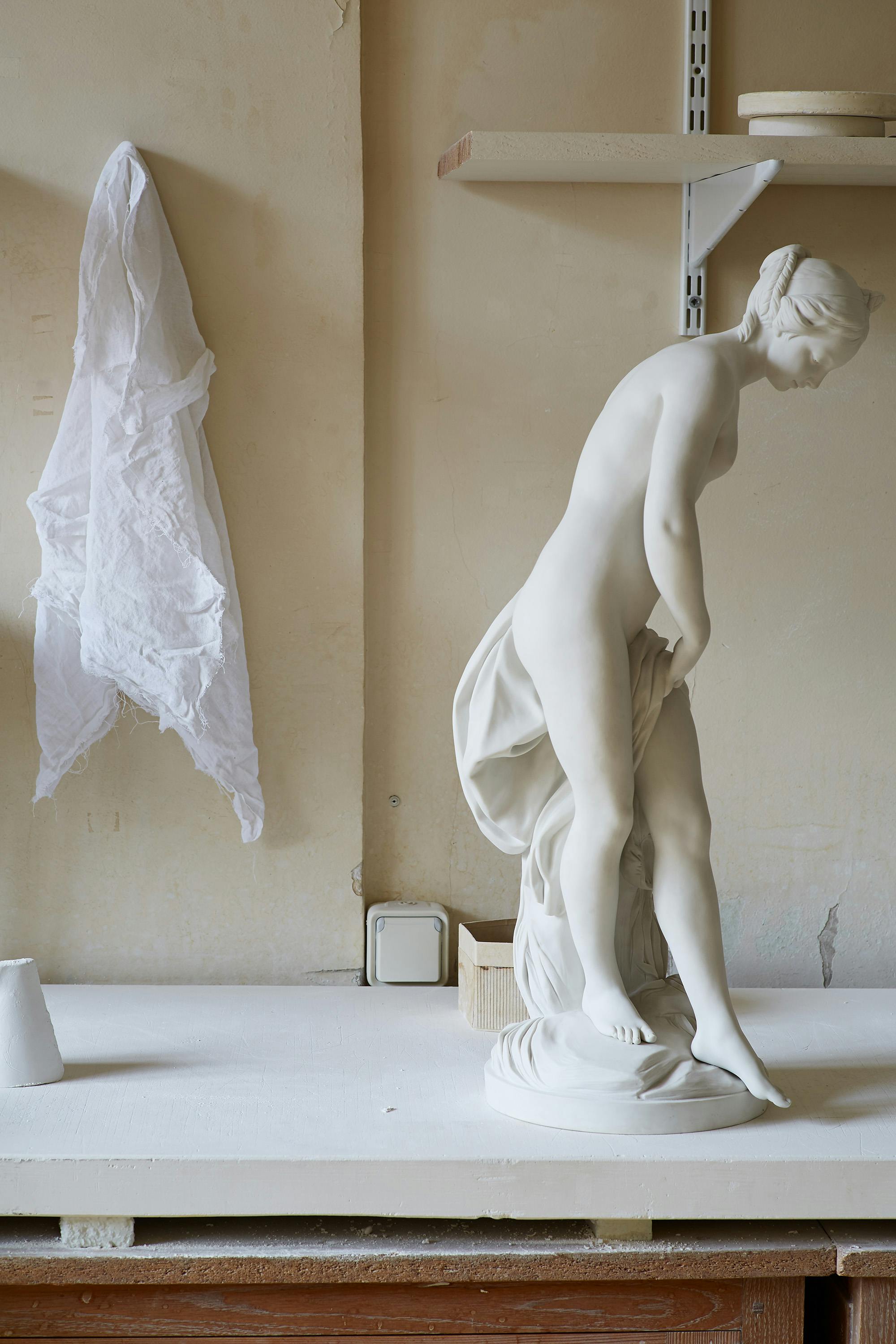 Porcelain statue of a woman with a white linen cloth