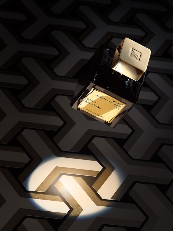 A floating perfume bottle against a black graphic background