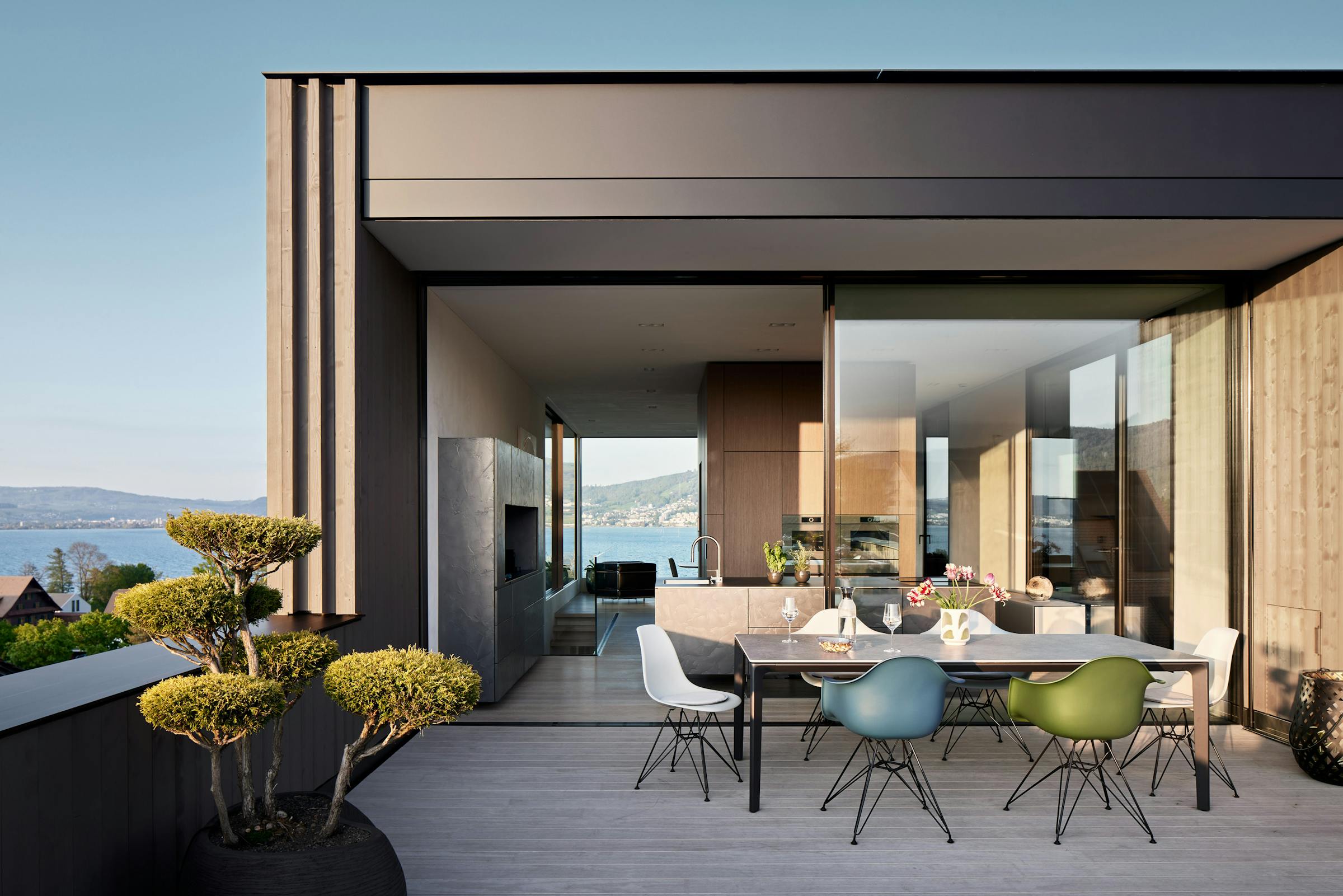 Large terrace with an outdoor table and colourful Eames chairs