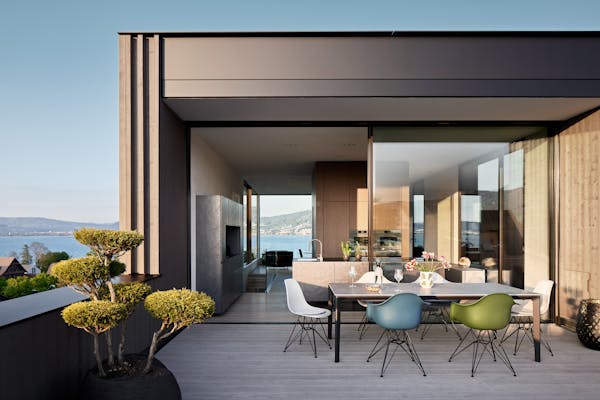 Large terrace with an outdoor table and colourful Eames chairs