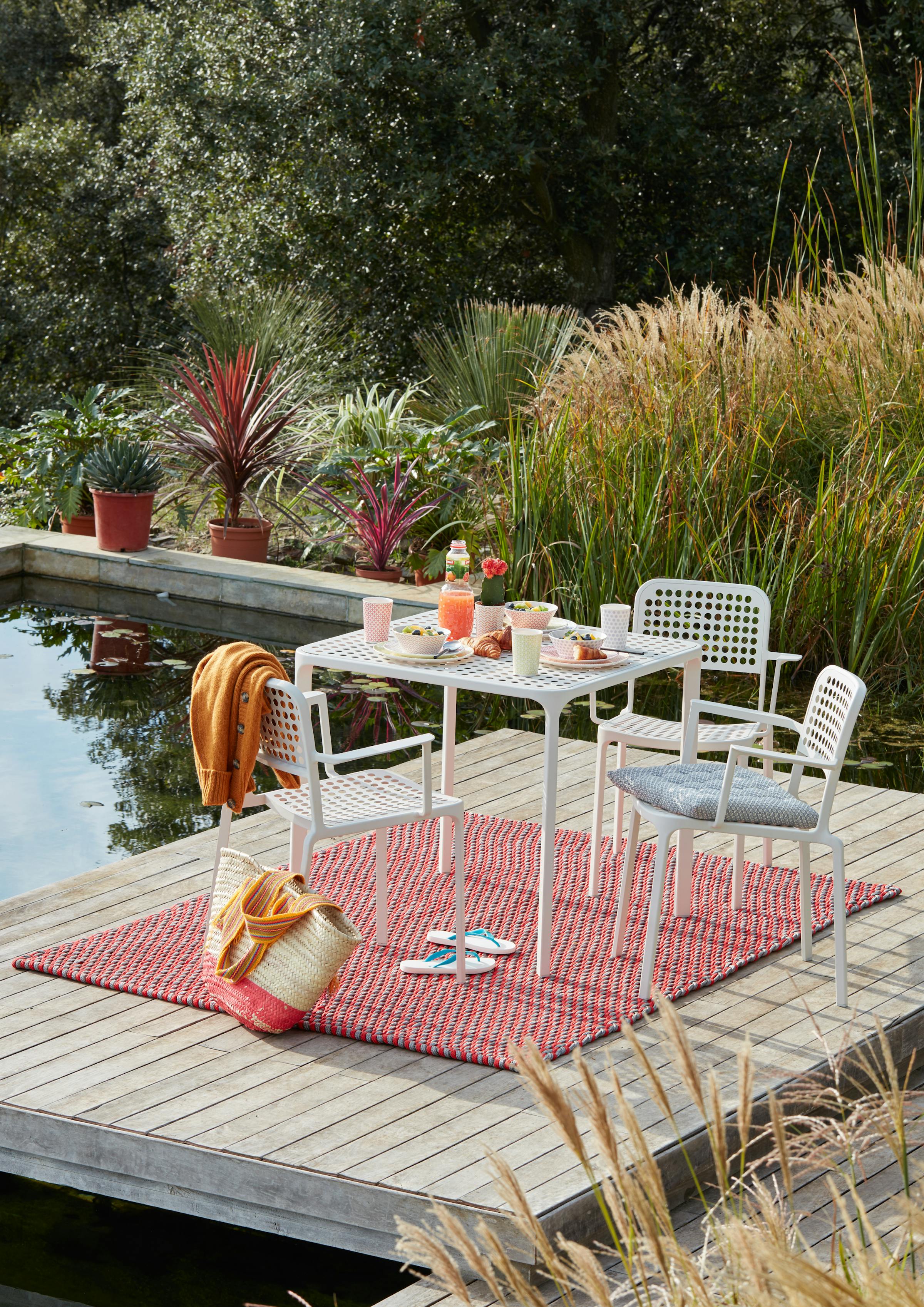 Small outdoor table with breakfast on a floating raft in a pool