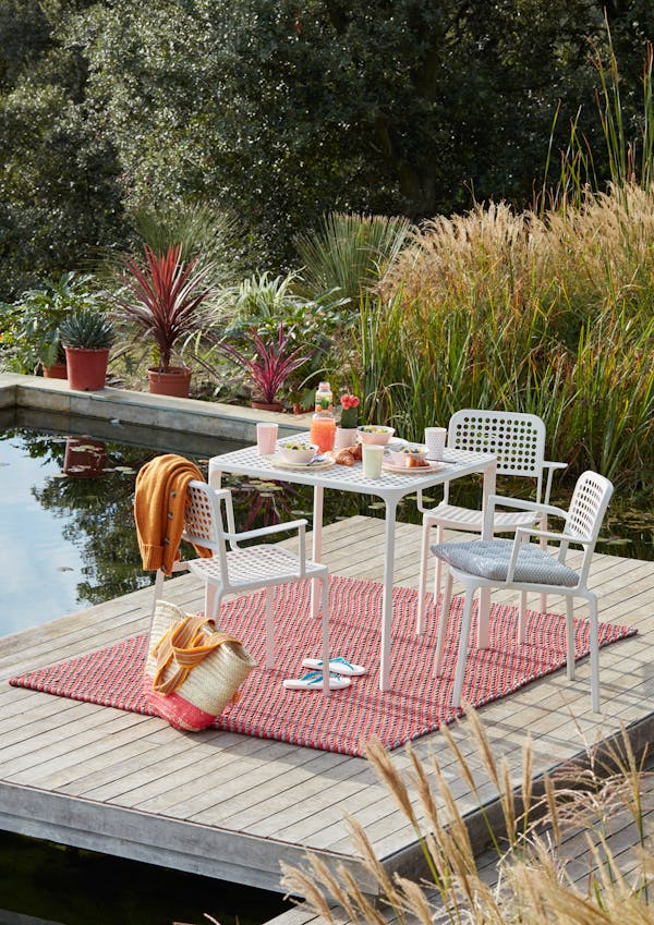 Small outdoor table with breakfast on a floating raft in a pool