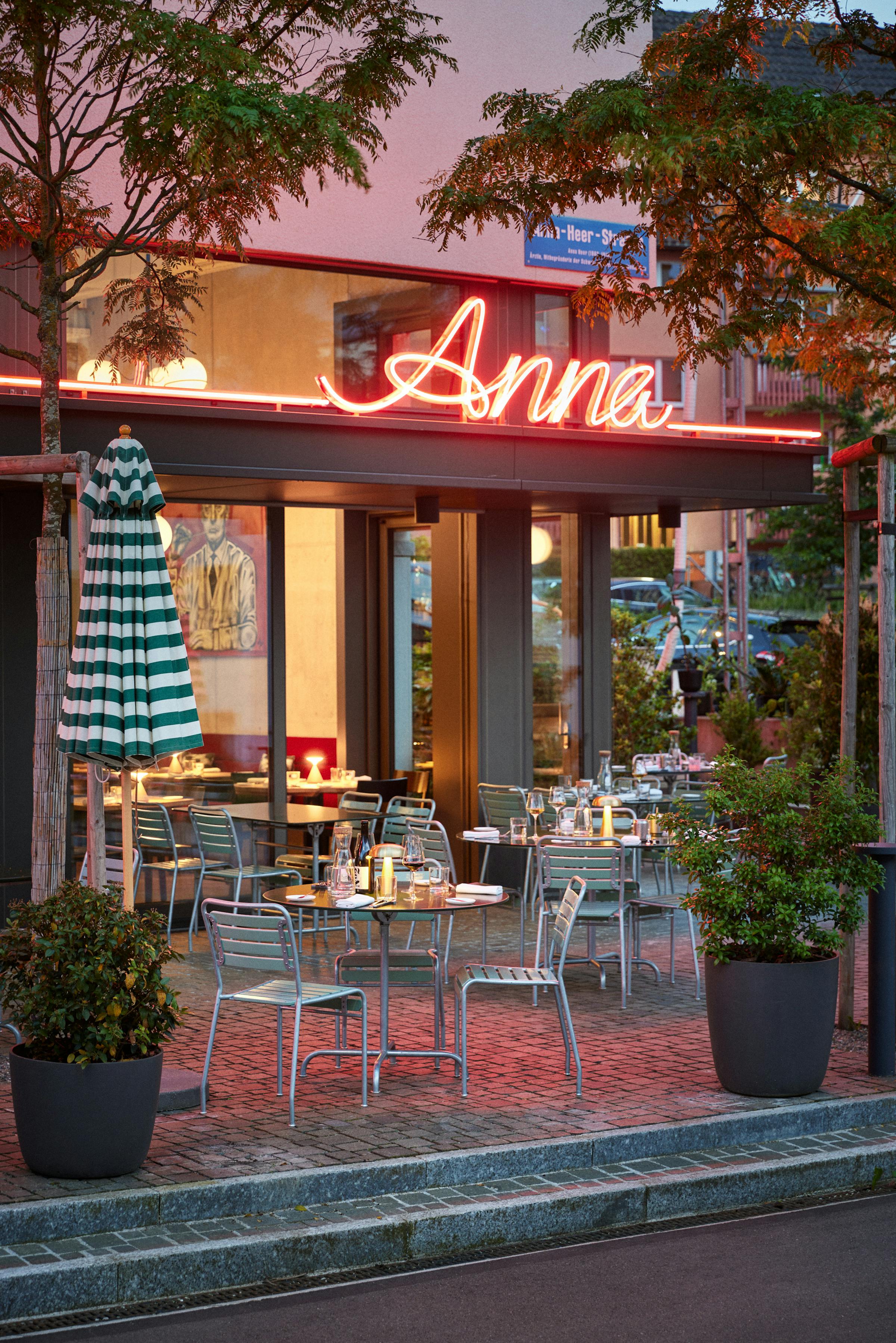 Facade of the restaurant anna in evening light with a neon sign in pink