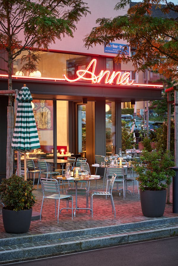 Facade of the restaurant anna in evening light with a neon sign in pink