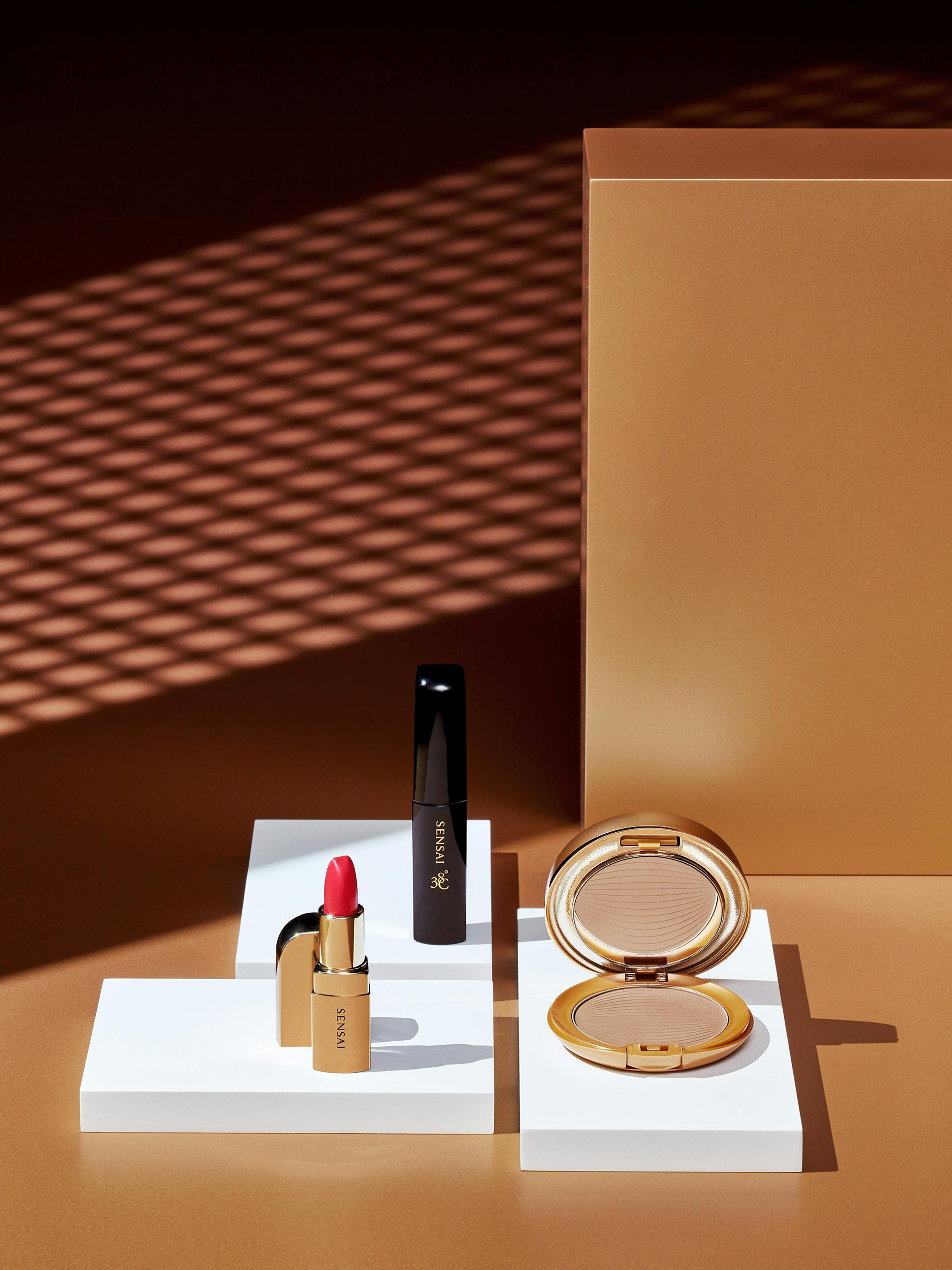 Beauty products on a bronze background with sharp graphic shadows