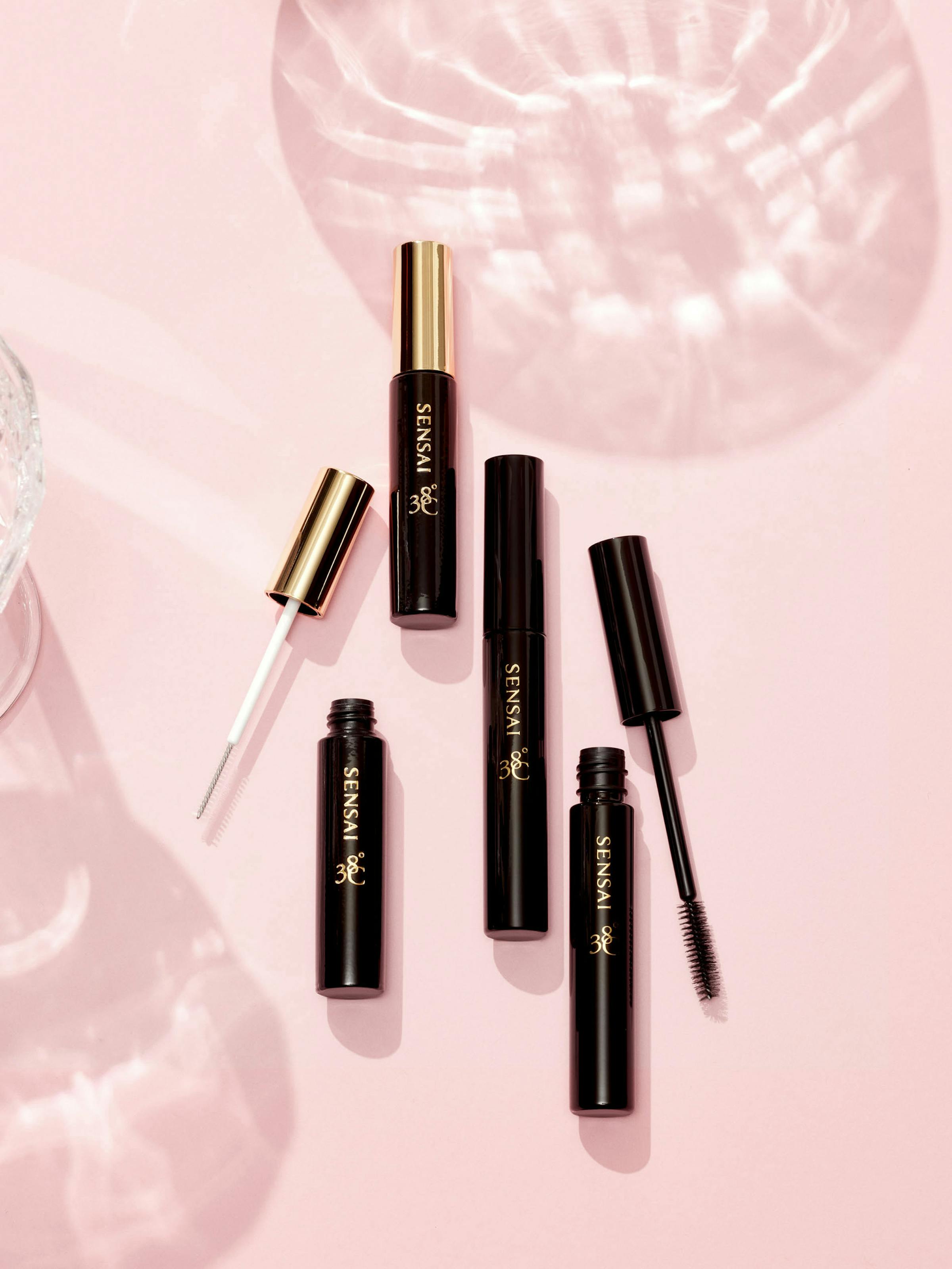 Maskaras on a light pink background