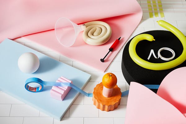 Colourful arrangement of tools and porcelain objects on pink foam