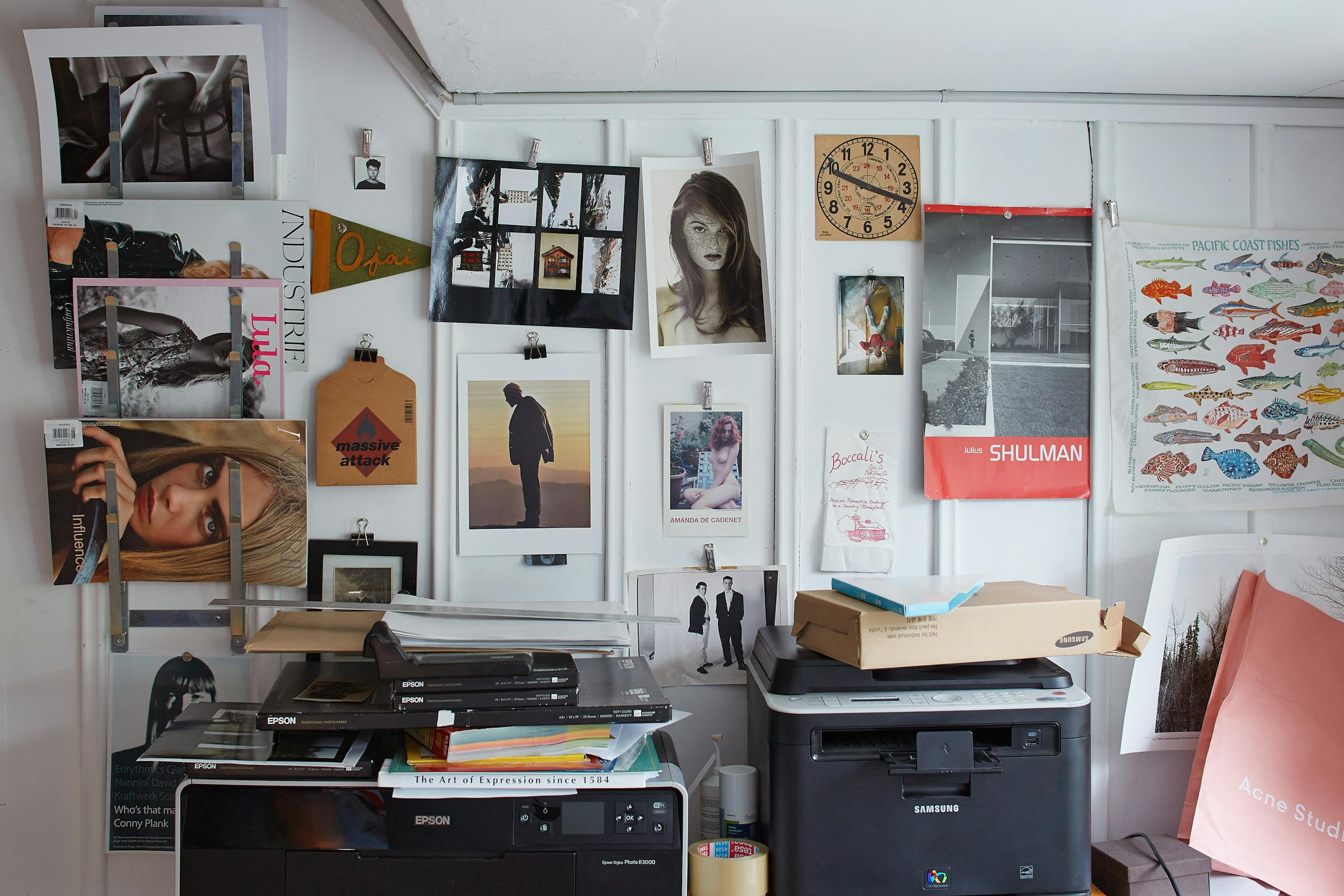 Wood panelled wall with many photo postcards hung on it for inspiration