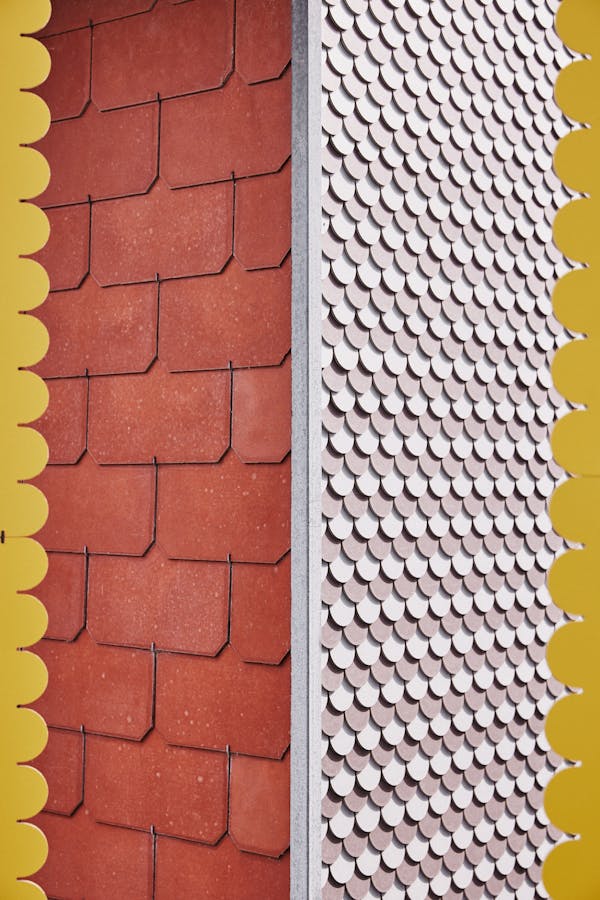 An Eternit façade with orange and white Eternit shingles framed by yellow Eternit shingles