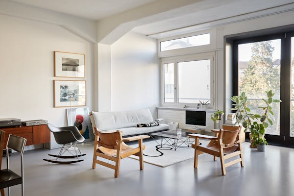Living room with a light-coloured sofa and two Scandinavian leather armchairs in a loft