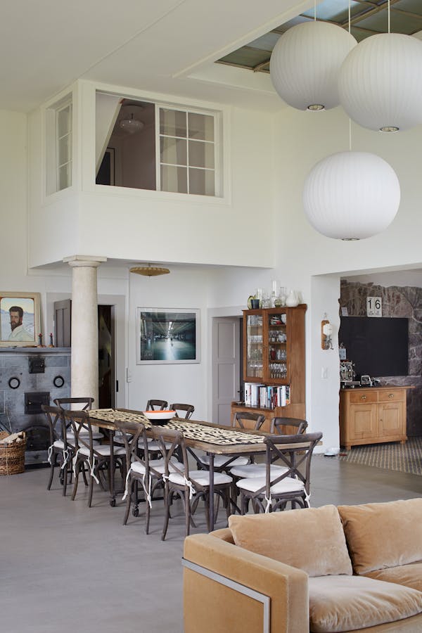 Dining table in a high-ceilinged interior with white pendant lights