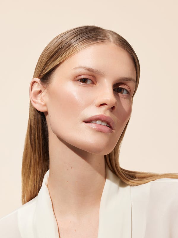 Beauty shot of a blonde woman in front of a light beige background