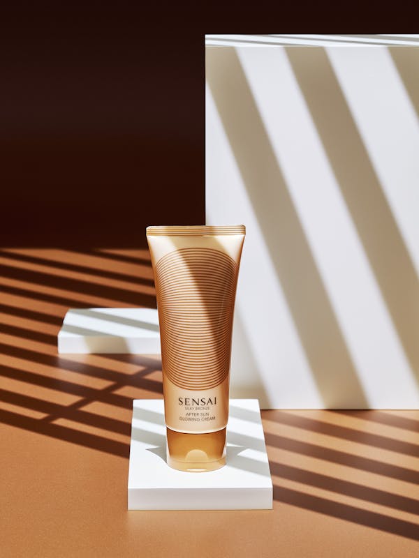 After sunscreen tube on a bronze background with sharp graphic shadows