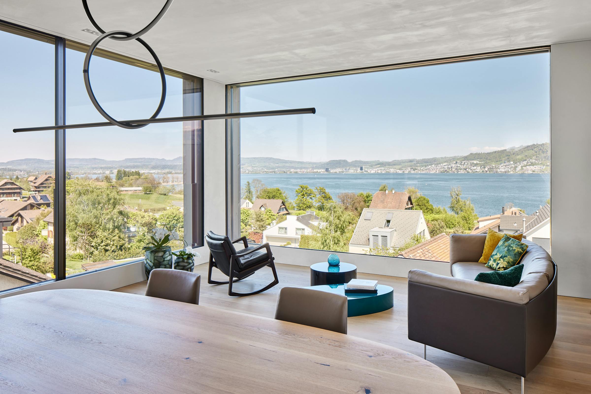 Living room with a sofa and an armchair with a view of Lake Zug