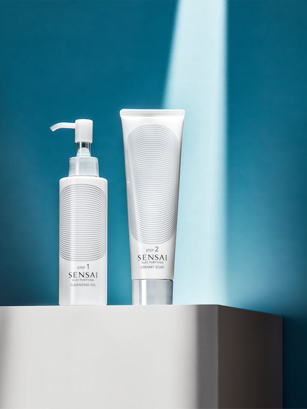 Beauty products in front of a light blue wall with sharp light rays