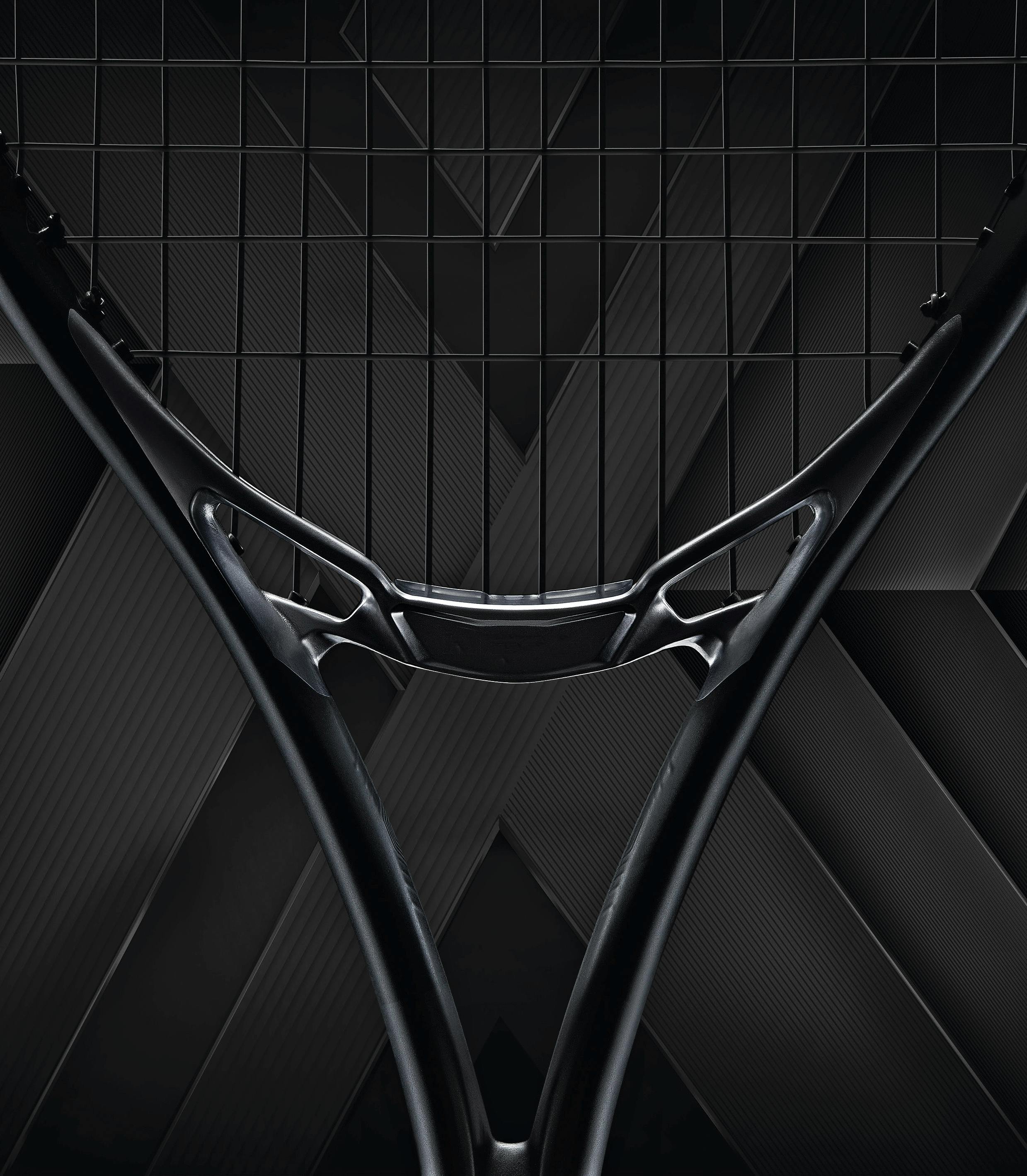 Packshot of a new Head MXG tennis racket in black on a black background