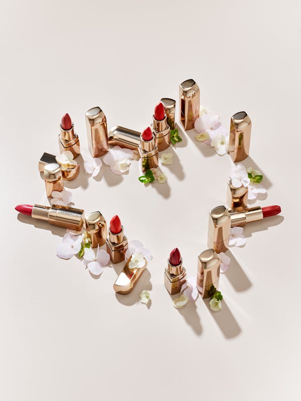 Lipsticks on a beige background in the shape of a heart