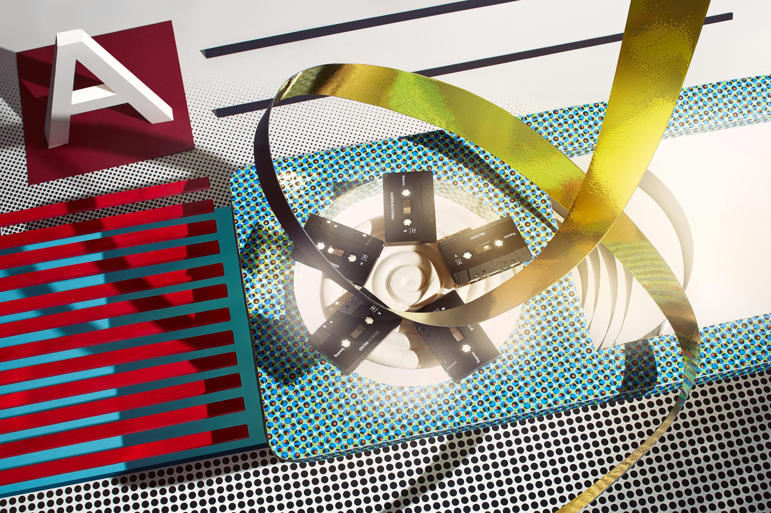 Five cassettes in an abstract set design and a golden sound loop