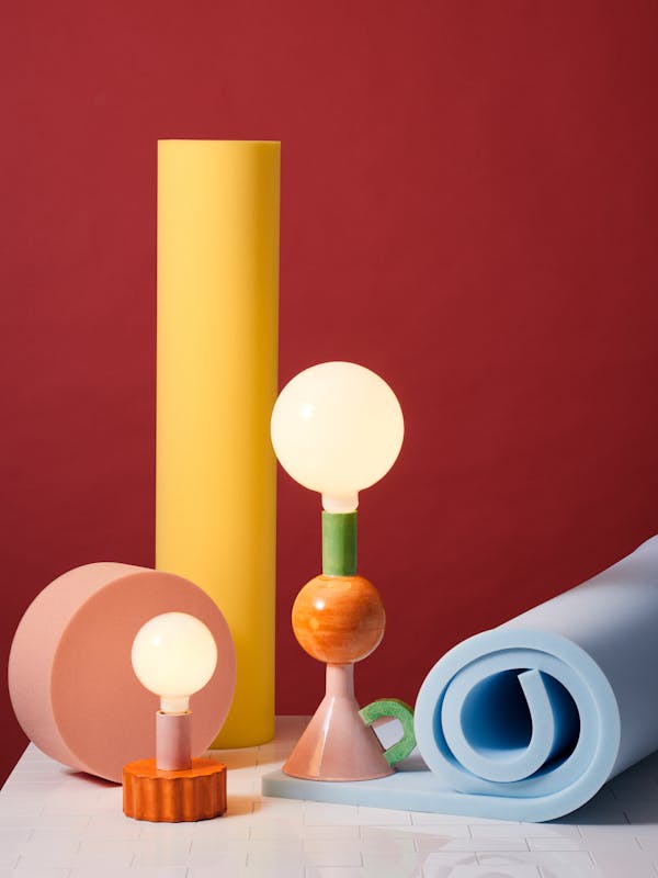 Colourful porcelain lamps in a foam set against a red background