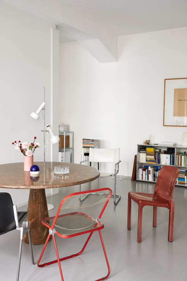 Dining room with a red Italian stone table surrounded by four different chairs