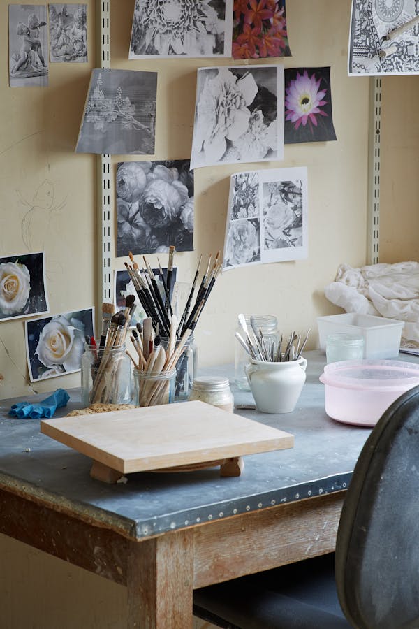 Table of a porcelain craftsman with photographs of flowers on the wall