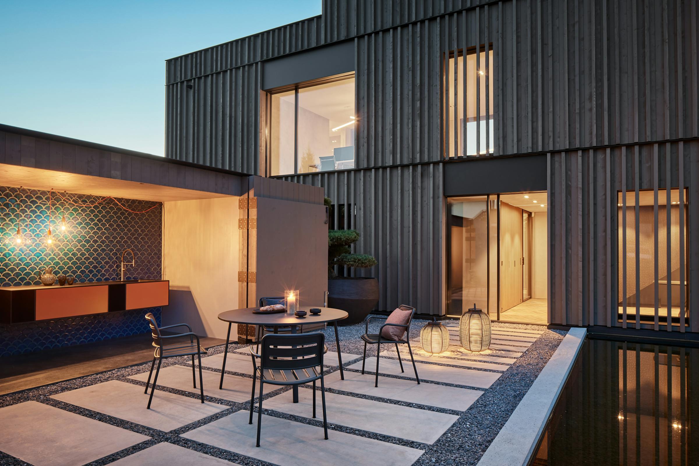 Inner courtyard at dusk with an outdoor table and four chairs