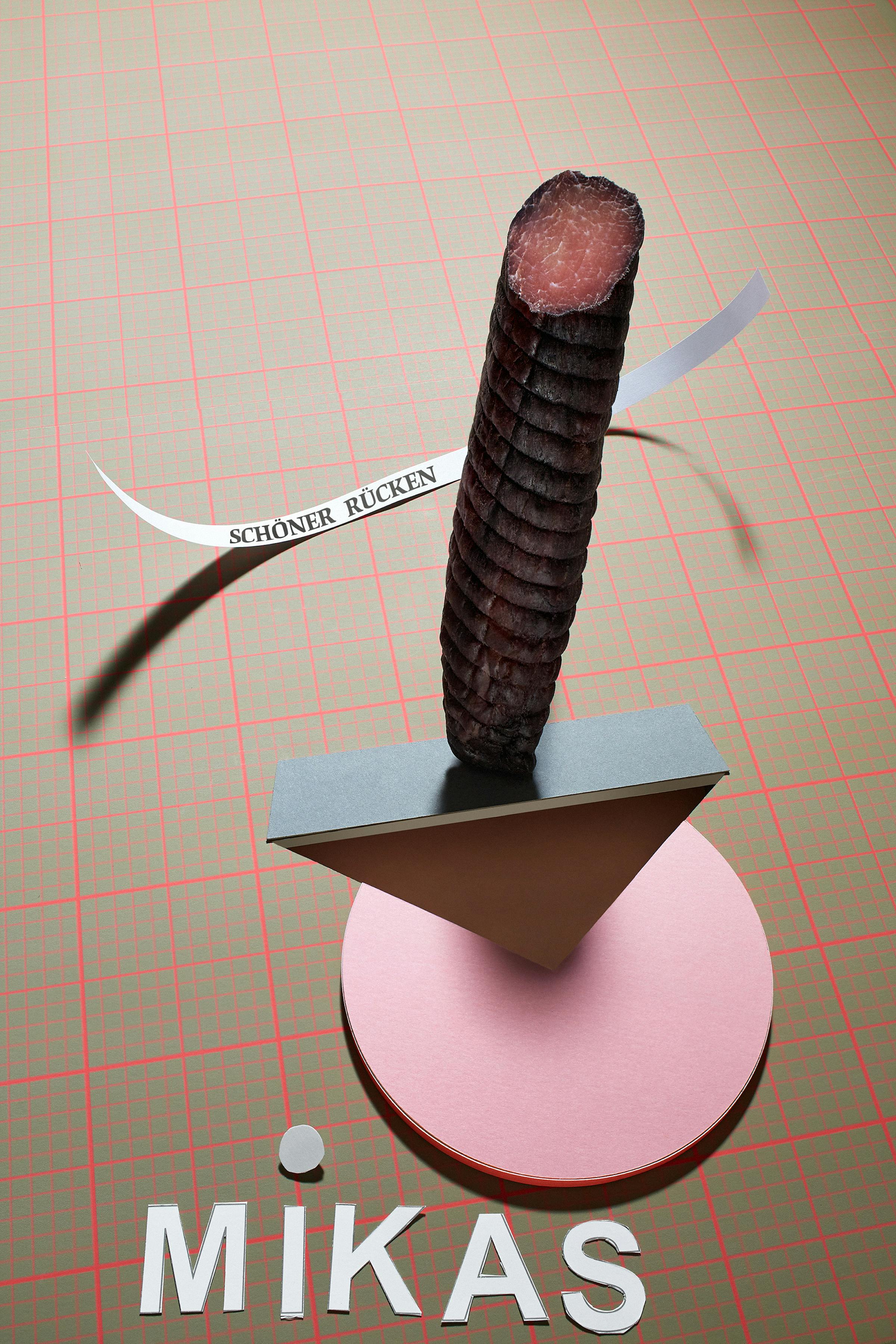 Dry sausage in a graphic setting made of beige paper with a millimetre pattern