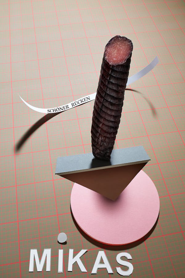 Dry sausage in a graphic setting made of beige paper with a millimetre pattern