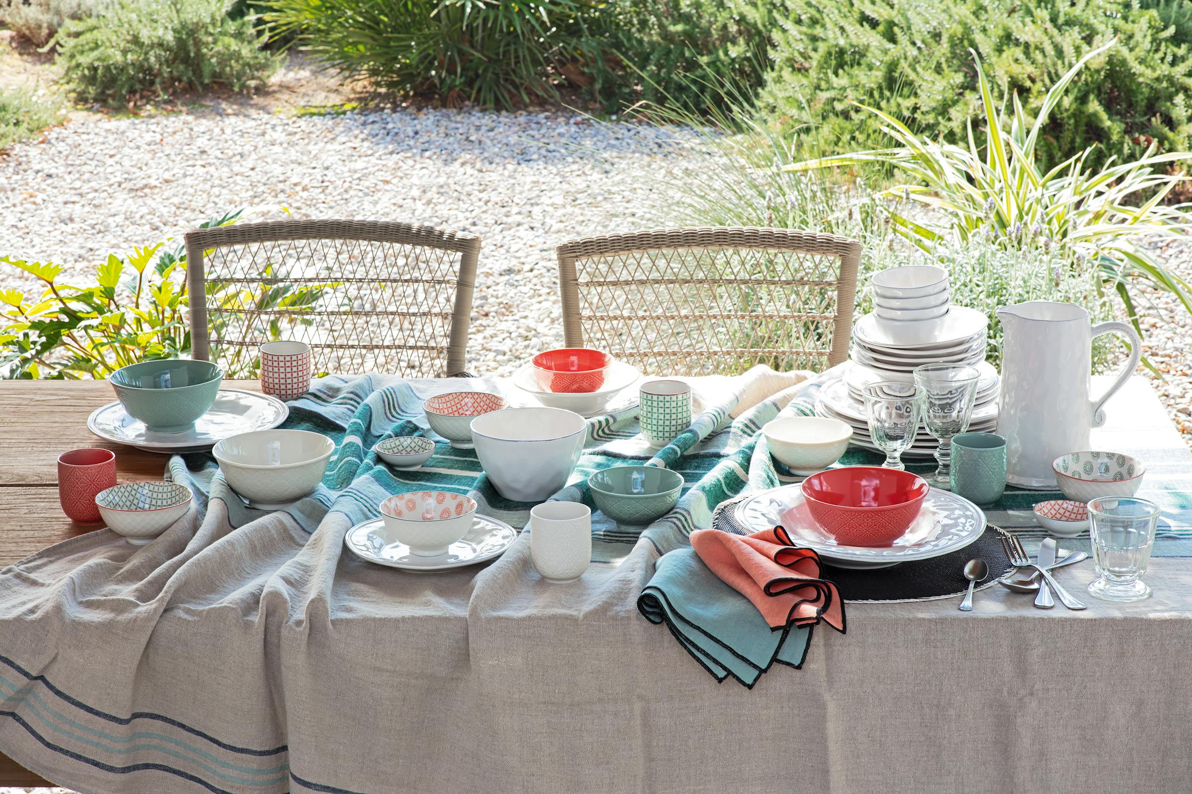 Plates and bowls on a table covered with a linen cloth in summer