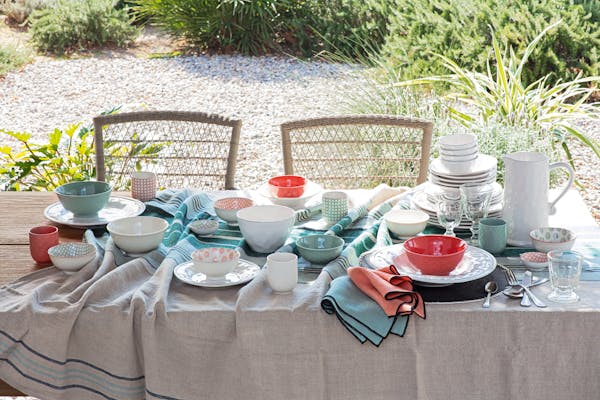 Plates and bowls on a table covered with a linen cloth in summer