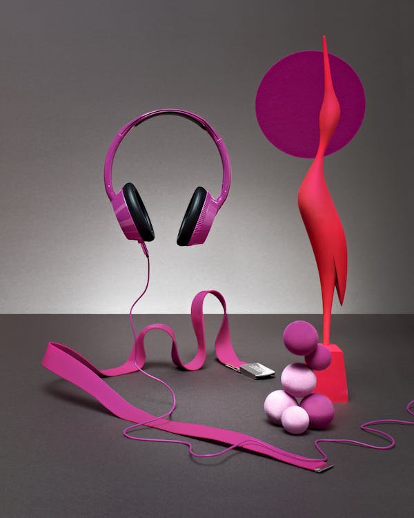 Headphones, a belt and a crane in purple and red, sculpturally staged together