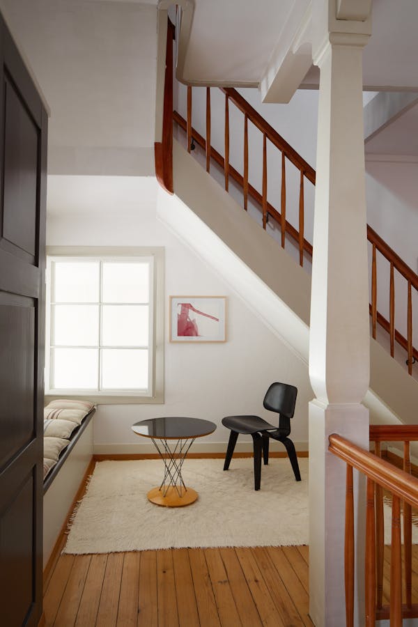 Black Eames plywood chair in a white stairwell