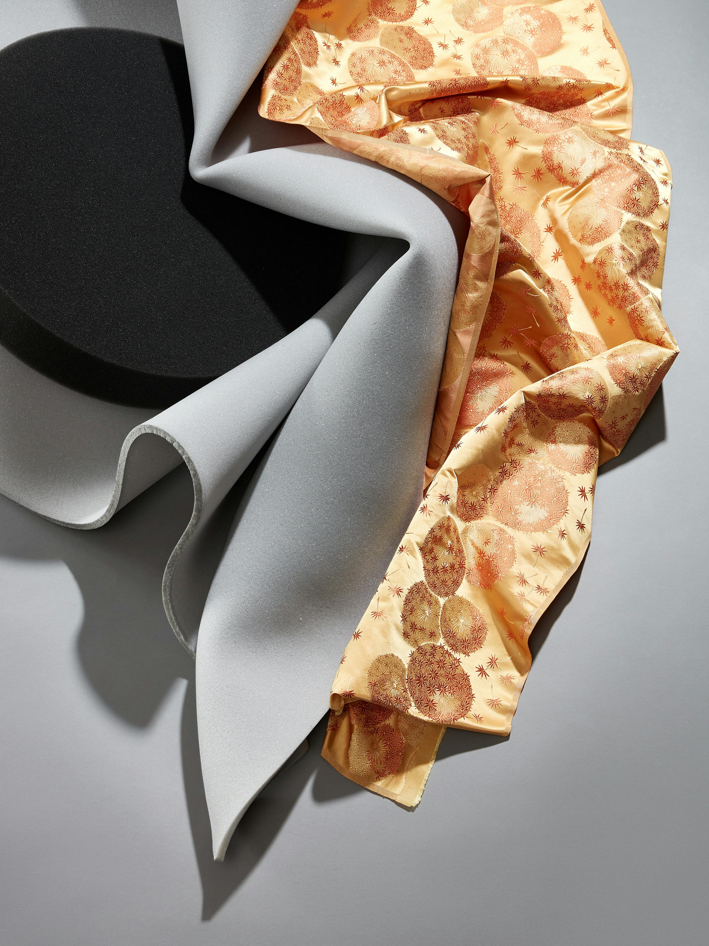 Close-up of a light orange fabric from the 19th century with grey foam