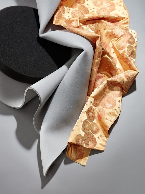 Close-up of a light orange fabric from the 19th century with grey foam
