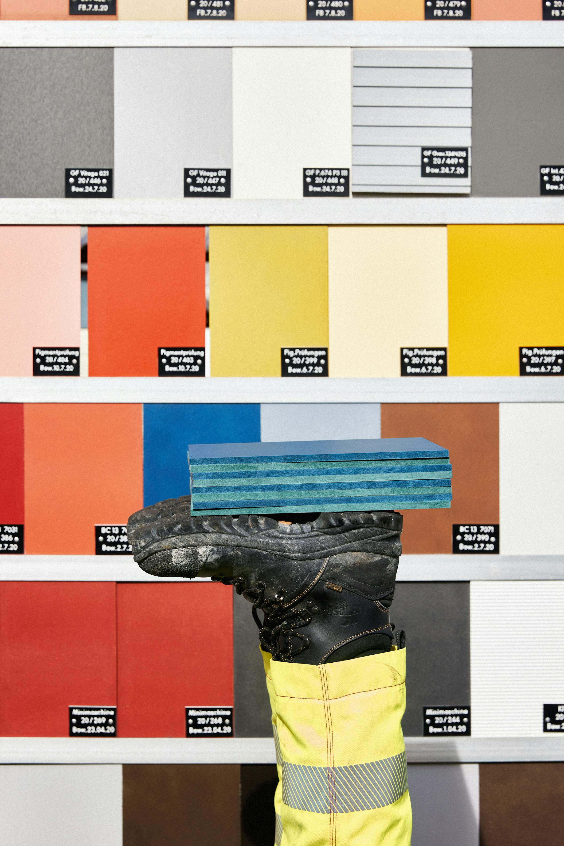 Eternit test panels with a human foot on which other Eternit panels are stacked