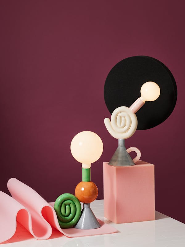 Colourful porcelain lamps in a foam set against a dark purple background