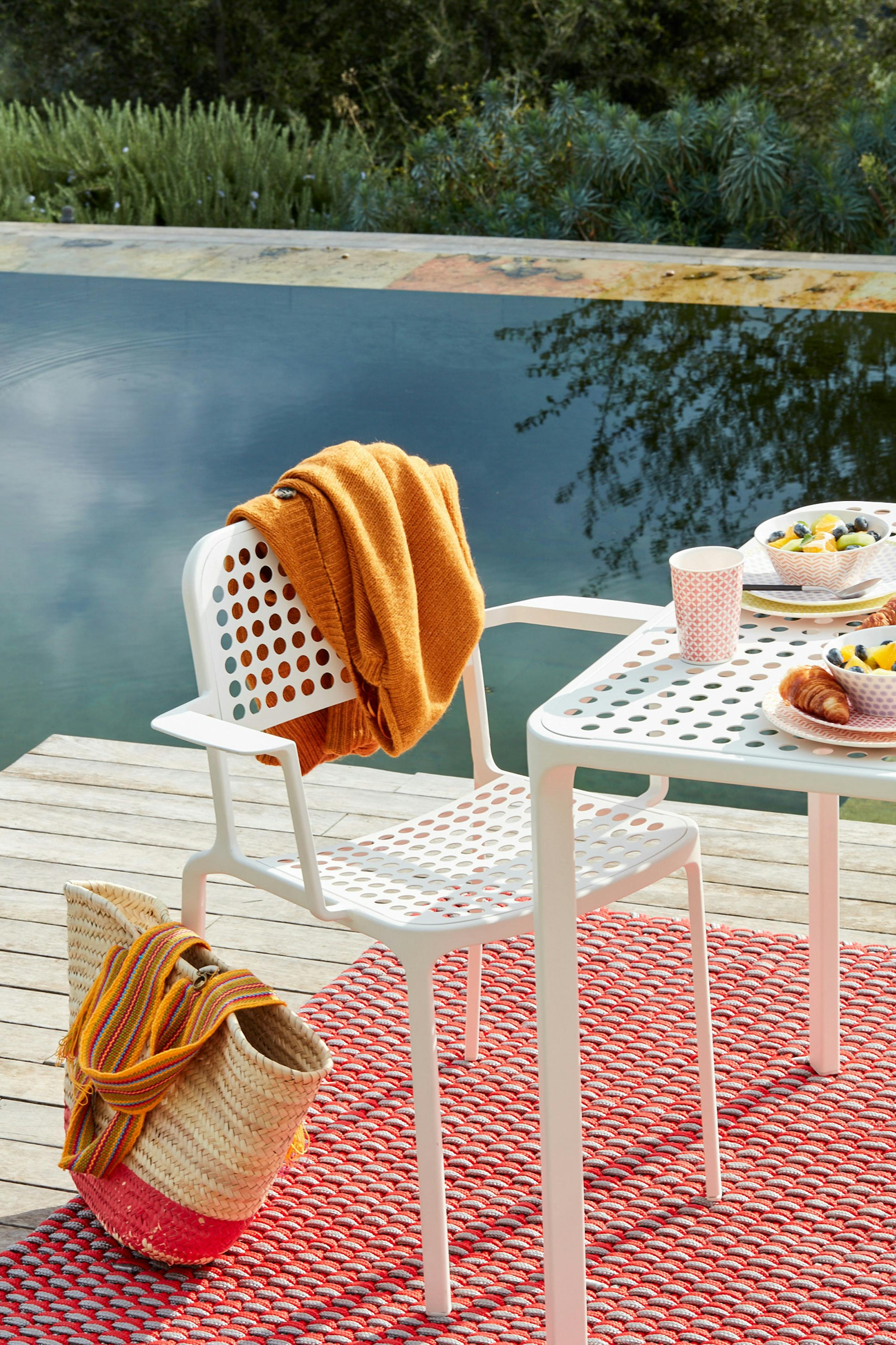 Close-up of a white outdoor chair on a floating raft in a pool