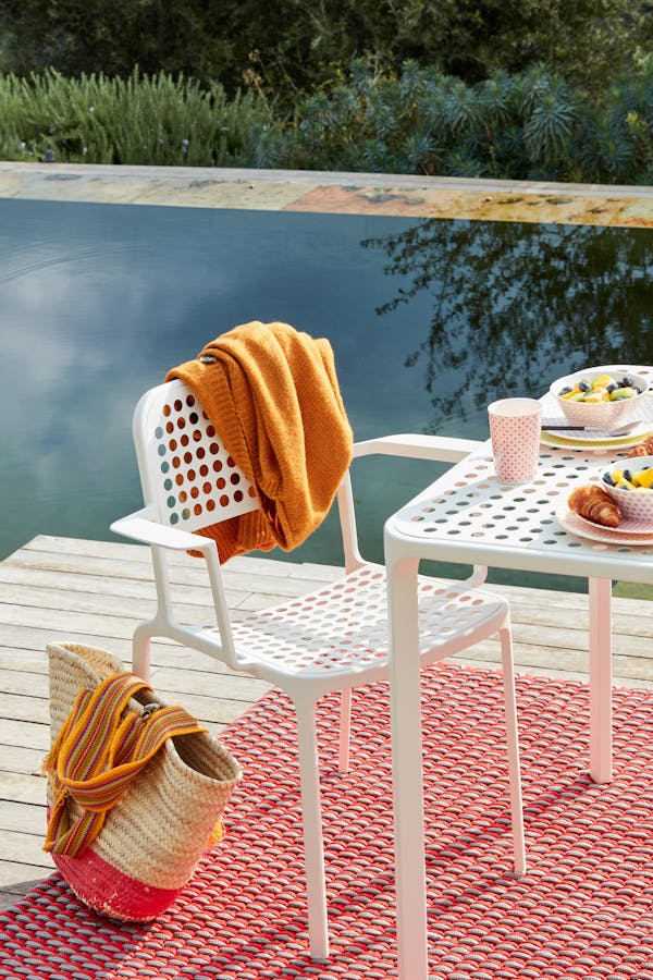 Close-up of a white outdoor chair on a floating raft in a pool