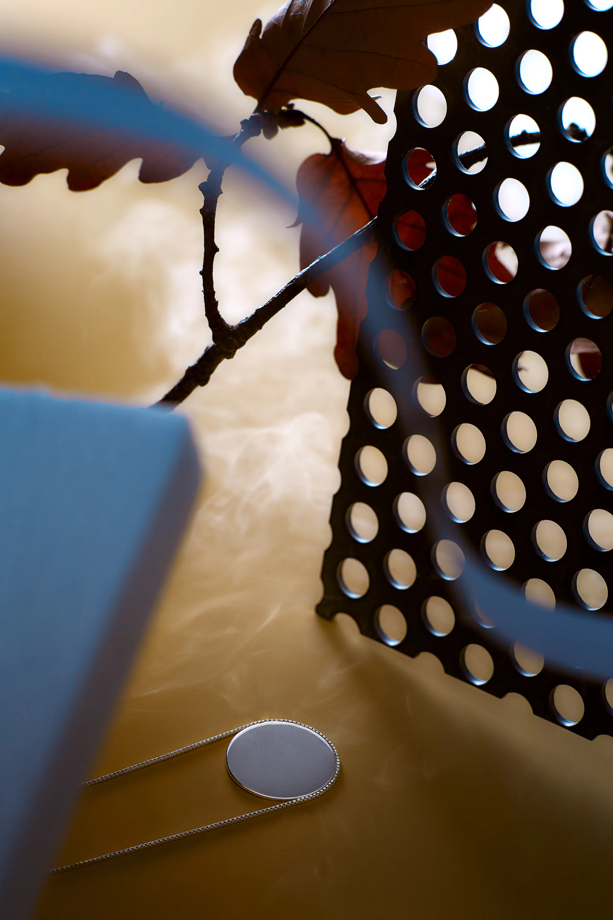 Necklace in an orange-yellow setting with black perforated metal