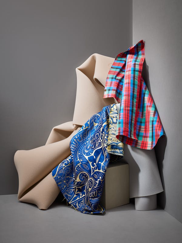  Colourful fabrics from the 19th century together with grey foam in a corner