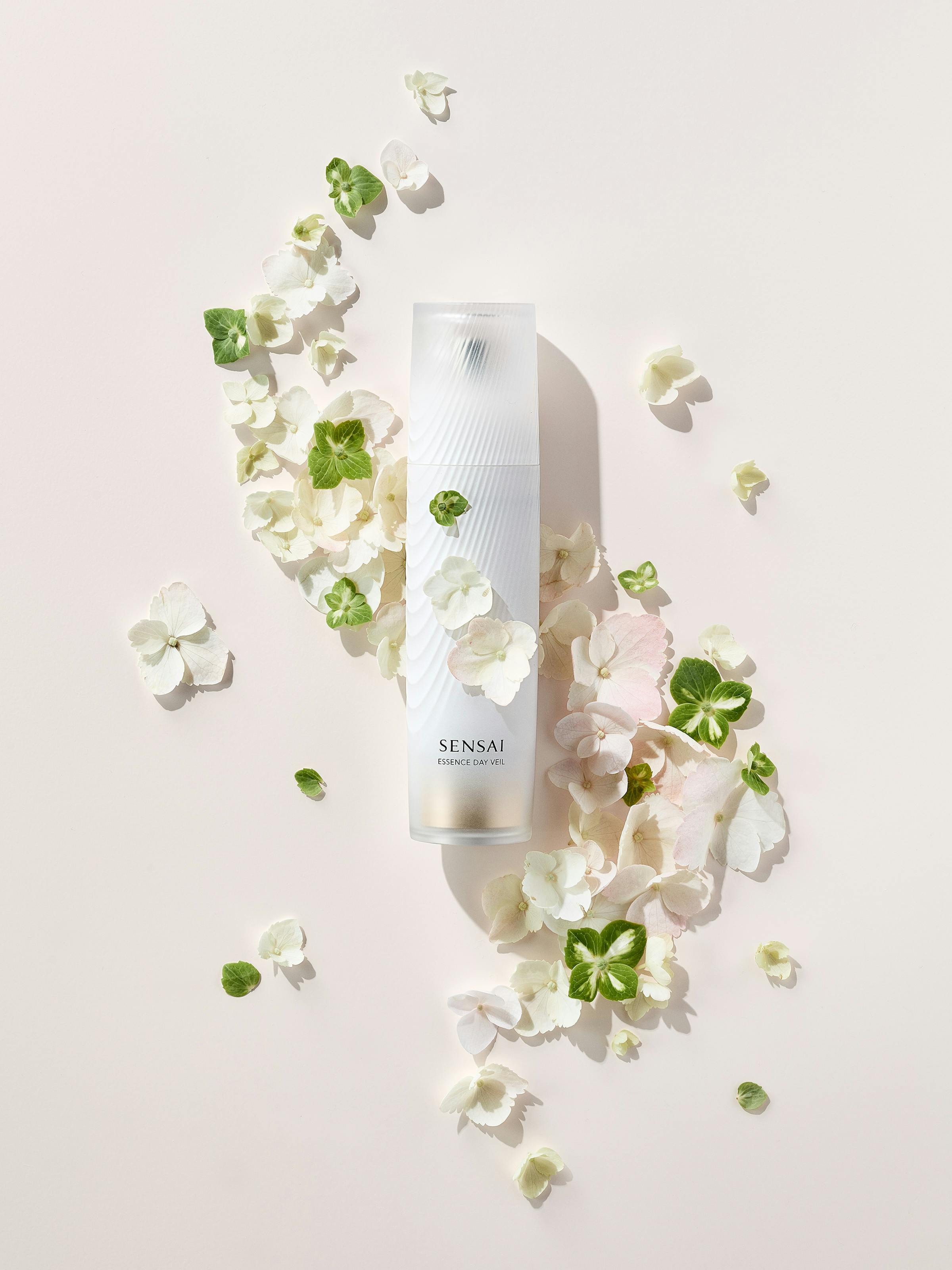 A white beauty product with green and pink flowers on a beige background