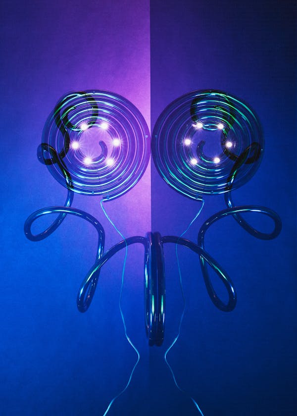 Multiple analogue exposure of the lamp Pizza Cobra by british designer Ron Arad in front of a vibrant dark blue violet background