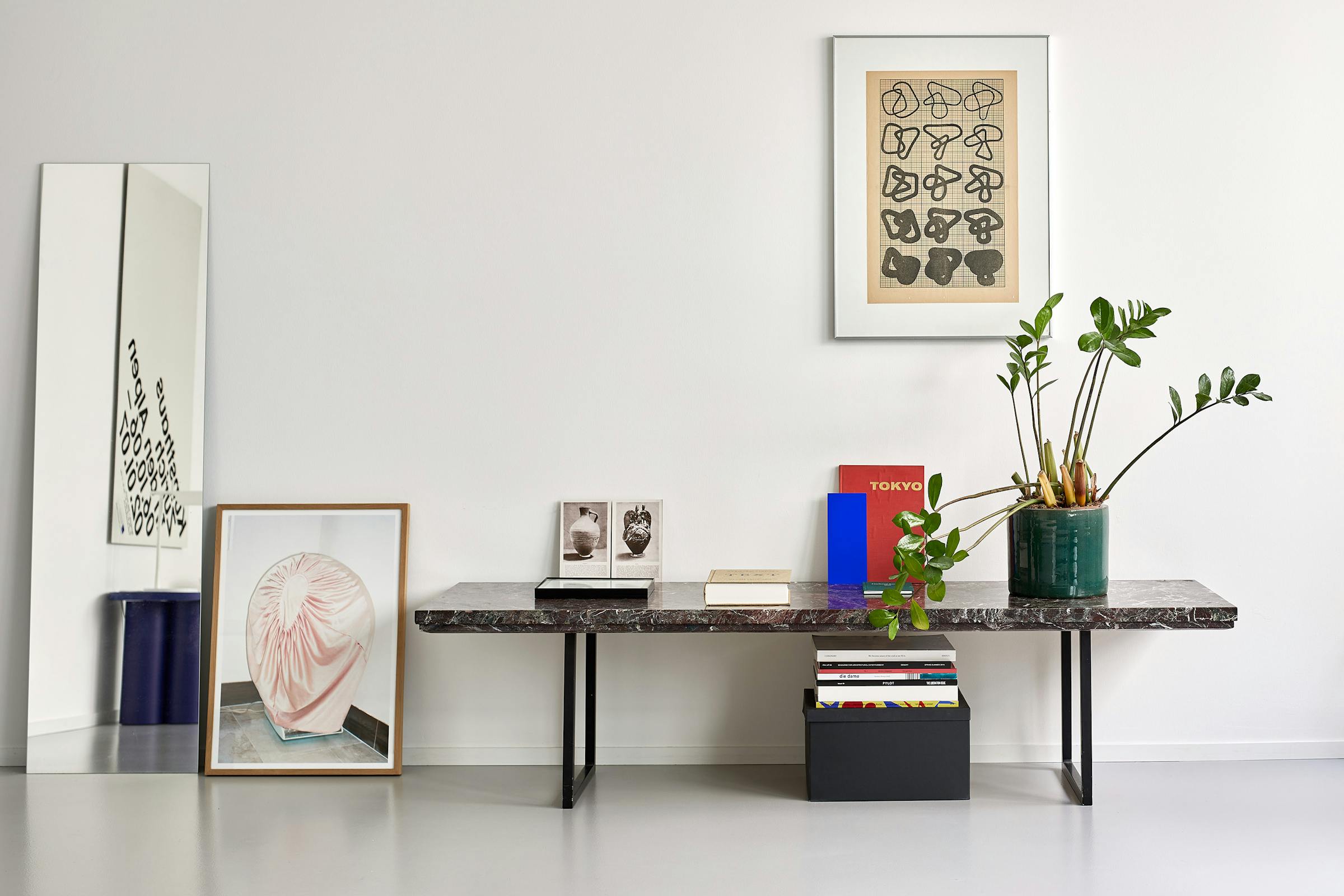 Coffe table in red marble with some books and a plant on it