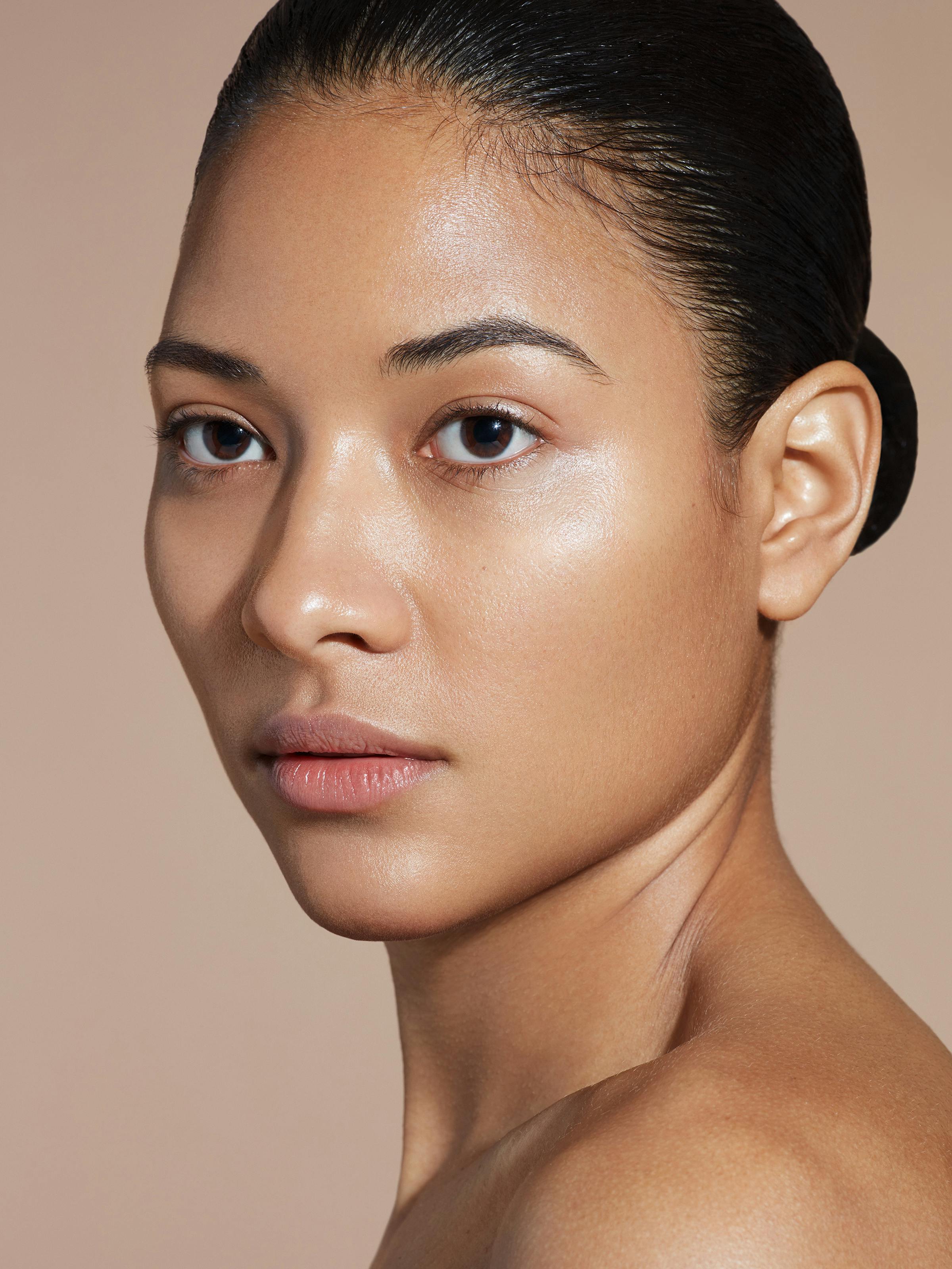Beauty shot of a young woman with her black hair pulled back tightly