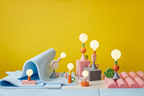 Colourful group of porcelain lamps in a foam set against a bright yellow background